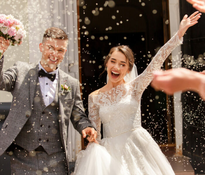 Happy wedding photography of bride and groom at wedding ceremony. Wedding tradition sprinkled with rice and grain