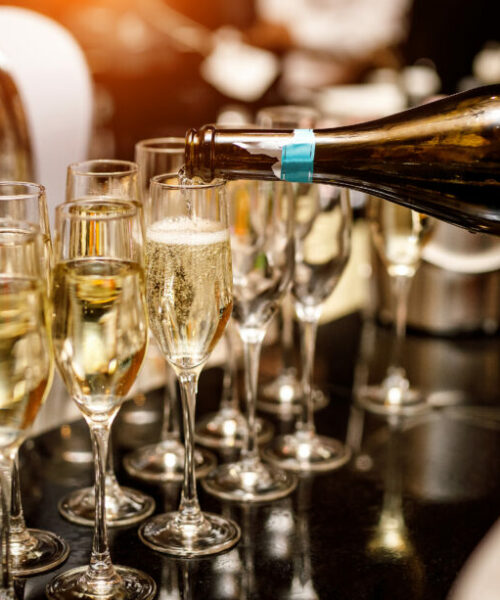 Waiter filling a glass of champagne in a restaurant